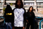 Three models wearing Pave The Wave long-sleeve tops outdoors.
